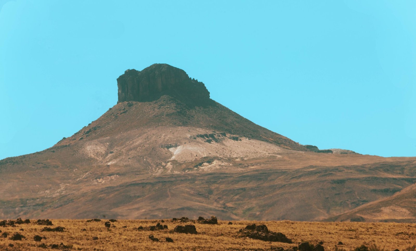 Dramatic rock formation under clear blue sky in the Peruvian Andes near Cusco.