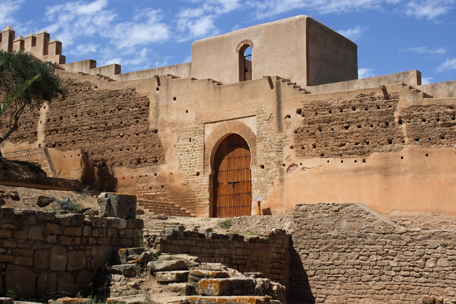 Historic stone fortress with arch doorway and blue sky backdrop, ideal for travel enthusiasts.