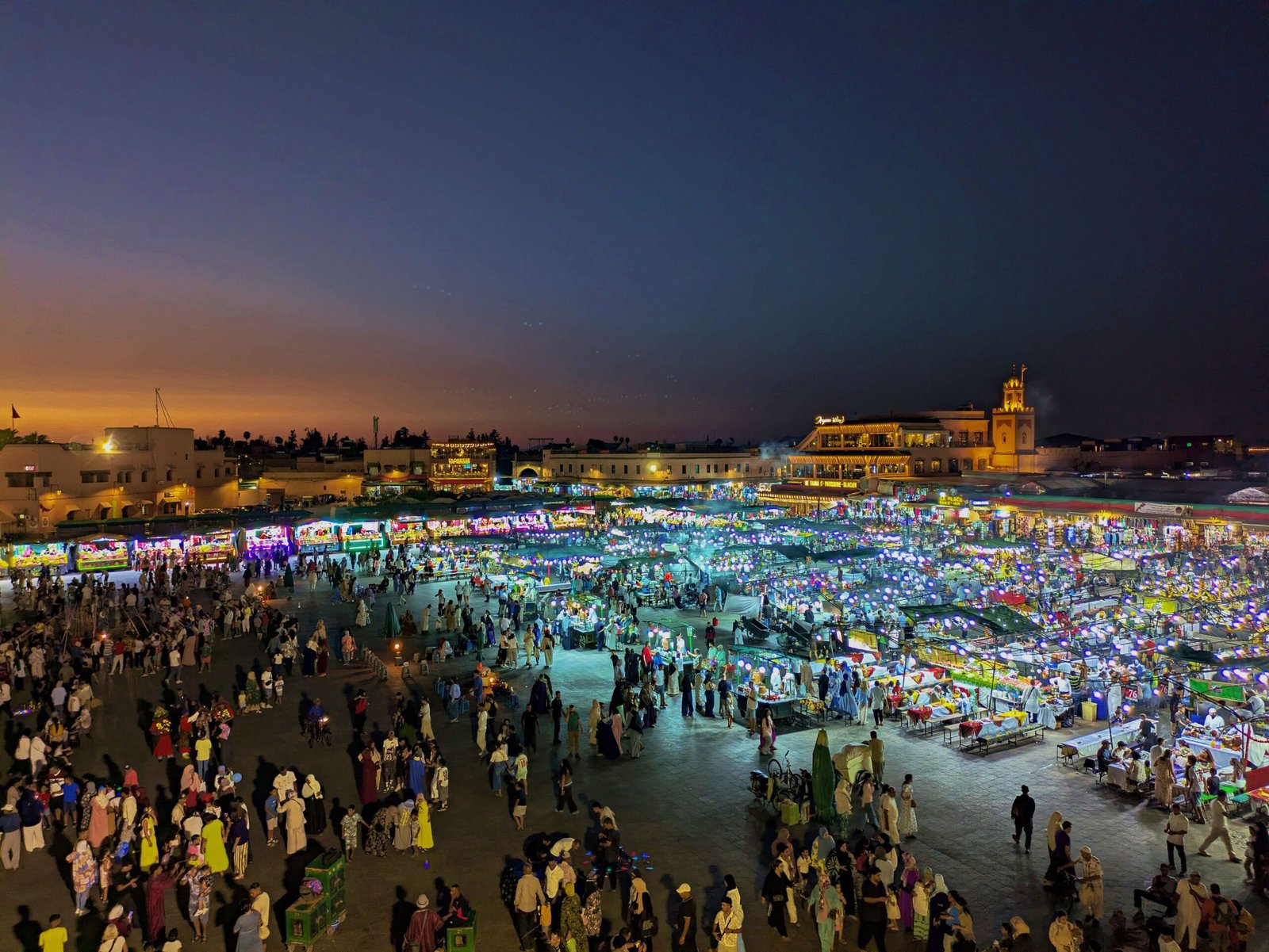 Captivating evening scene at bustling Jemaa el-Fnaa market in Marrakesh.