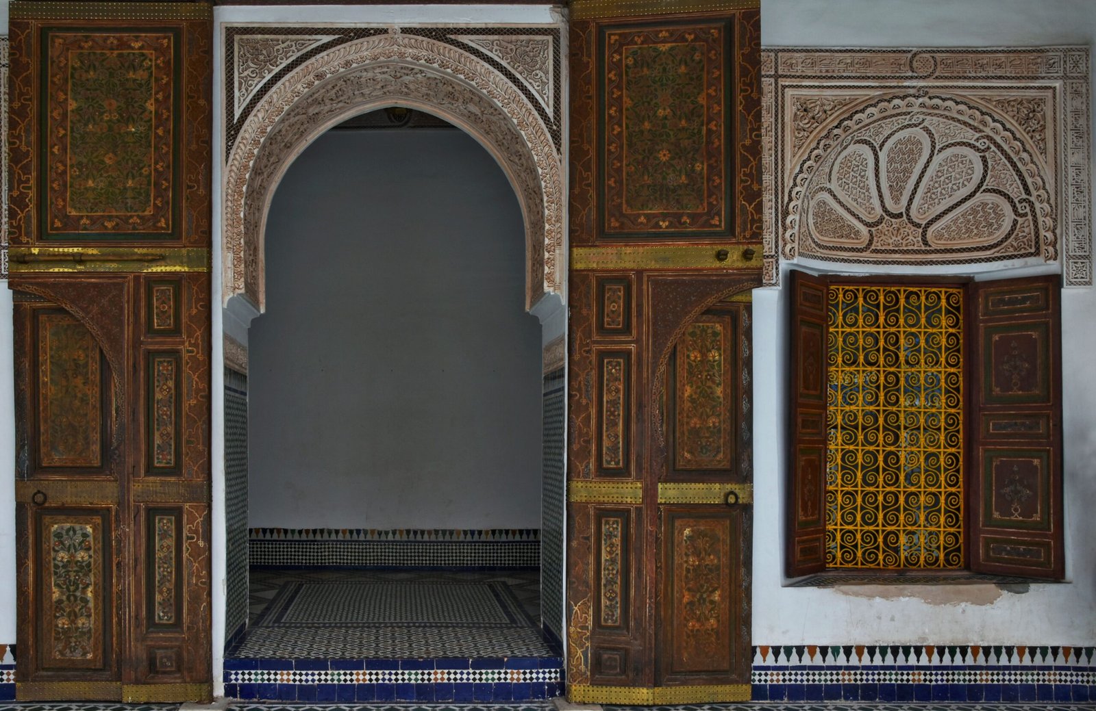 Detailed view of Moroccan arches and ornate doors at Bahia Palace, Marrakech.